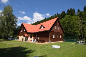 a large wooden cabin with a red roof at Apartments White - Hill in Černý Dŭl