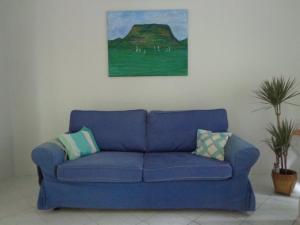 a blue couch in a living room with a painting at Luca-lak in Fonyód