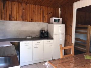 a kitchen with a white refrigerator and a microwave at Camping Mon Repos in Montmaur