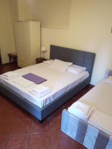 a bedroom with a large bed with white sheets at Atlantis in Ermoupoli