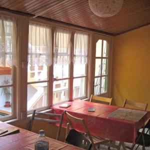 comedor con mesa y algunas ventanas en Hostel Tenerife, en La Orotava