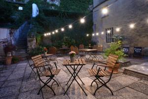 a patio with tables and chairs at night with lights at Hotel Krone 1512 in Salzburg