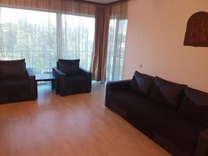 sala de estar con sofá, 2 sillas y mesa en St.Vlas Apartments Mamaia, en Mamaia
