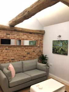 a living room with a couch and a brick wall at Rivers Rest in Norwich
