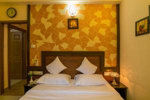 sypialnia z łóżkiem z 2 białymi poduszkami w obiekcie Blue Bell Cochin Airport Hotel w mieście Nedumbassery