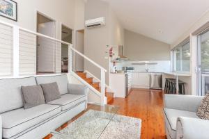 a living room with a couch and a table at Wine Country Villas in Pokolbin