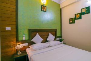 sypialnia z białym łóżkiem i zieloną ścianą w obiekcie Blue Bell Cochin Airport Hotel w mieście Nedumbassery