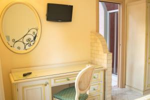 tocador con espejo y silla en Hotel Ginevra, en Poggiomarino