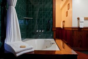 a bathroom with a tub and a shower with a towel at Mirror Lake Inn Resort and Spa in Lake Placid