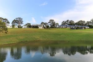 a lake with a large body of water surrounded by trees at Wine Country Villas in Pokolbin