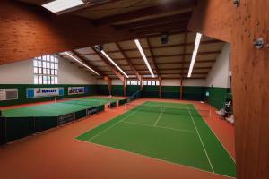 una pista de tenis cubierta en un edificio con pista de tenis en K-Triumf Resort, en Velichovky