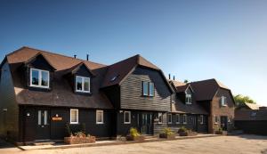 een rij huizen met zwarte daken bij The Cottages at Crouchers Orchards in Chichester