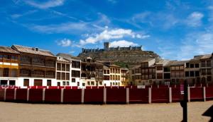 a group of buildings with a castle on the hill at La Casita de la Planta in Quintanilla de Onésimo