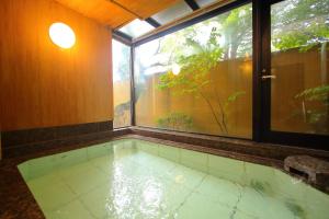 a swimming pool in a room with a window at Hatago Tsubakiya in Yamanakako