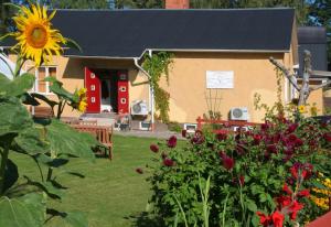 una casa con un girasol delante de un patio en Bed & Breakfast Björkhyddan, en Rumma