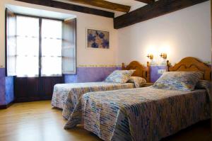 Aria的住宿－Casa Rural ERTEIKOA - Selva de Irati，一间卧室设有两张床和窗户。