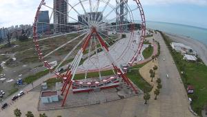 a large ferris wheel on a hill next to the ocean at Apartment Georgy in Batumi