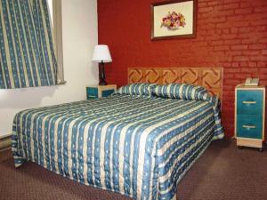 a bedroom with a bed with a blue and white comforter at Hotel Ste-Catherine in Montréal