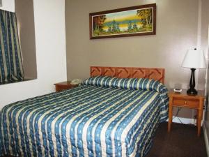 a bedroom with a bed with a blue and white comforter at Hotel Ste-Catherine in Montreal