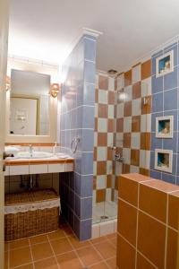 een badkamer met een wastafel en een douche met een spiegel bij Apelon Tiritas Villas in Leonidion