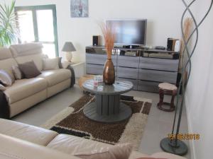 a living room with a couch and a vase on a table at TESS Villa Fournadin in Fournaudin