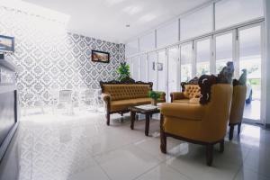 a living room with couches and a table and chairs at RedDoorz near Hermes Place Polonia Medan in Medan