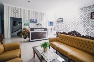 a living room with two couches and a tv at RedDoorz near Hermes Place Polonia Medan in Medan