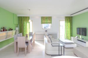 a living room with green walls and a table and chairs at Corfu Overview Penthouse in Corfu