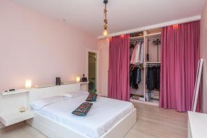a bedroom with a white bed with pink curtains at Corfu Overview Penthouse in Corfu
