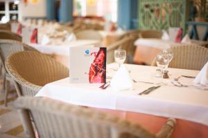 a table in a restaurant with white tables with wine glasses at Grupotel Playa Club in Son Xoriguer