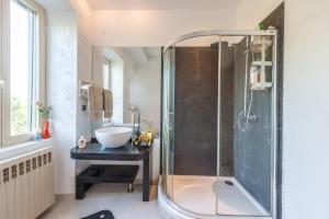 a bathroom with a glass shower and a sink at Corfu Overview Penthouse in Corfu +17 photos