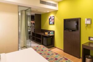 a hotel room with a bed and a flat screen tv at Keys Select by Lemon Tree Hotels, Visakhapatnam in Visakhapatnam
