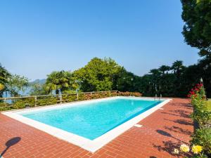 una piscina con alberi e patio in mattoni rossi di Belvilla by OYO Verdelago 16 a Citerna