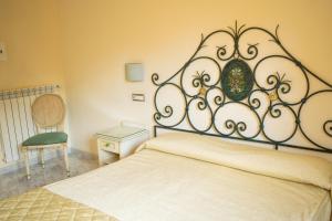 a bedroom with a bed with a metal head board at Hotel Ginevra in Poggiomarino
