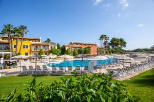 a resort with a pool and chairs and umbrellas at Grupotel Playa Club in Son Xoriguer