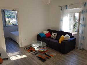 uma sala de estar com um sofá e uma mesa de vidro em Apartment Voyager em Dubrovnik