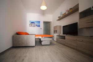 ein Wohnzimmer mit einem Sofa und einem Flachbild-TV in der Unterkunft Salento Sea & Sun in Porto Cesareo