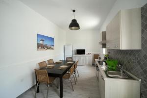 eine Küche und ein Esszimmer mit einem Tisch und Stühlen in der Unterkunft Salento Sea & Sun in Porto Cesareo