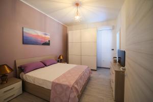 ein Schlafzimmer mit einem Bett und einem TV in der Unterkunft Salento Sea & Sun in Porto Cesareo