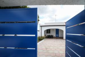niebieską bramą przed budynkiem w obiekcie Salento Sea & Sun w mieście Porto Cesareo