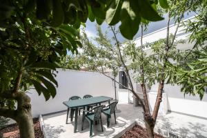 stół i krzesła na dziedzińcu z drzewami w obiekcie Salento Sea & Sun w mieście Porto Cesareo