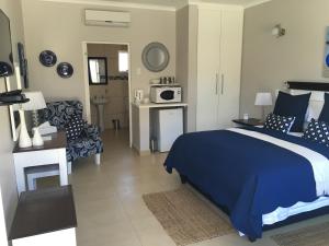 a bedroom with a blue bed and a couch at 44 on Brownlee in Kokstad