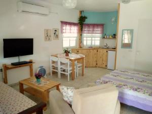 a living room with two beds and a kitchen at Jordan Valley one room apartment in Menaẖemya