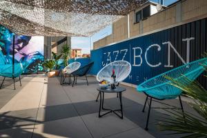 eine Terrasse mit Stühlen und Tischen auf einem Gebäude in der Unterkunft Habitat Apartments Cool Jazz in Barcelona