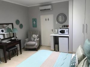 a bedroom with a bed and a desk and a chair at 44 on Brownlee in Kokstad