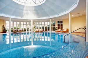a large swimming pool in a hotel with a large ceiling at Grupotel Playa Club in Son Xoriguer