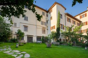 een binnenplaats van een gebouw met banken en gras bij Hostel Archi Rossi in Florence