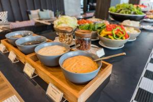 a buffet with bowls of food on a table at The Residence on Thonglor by UHG in Bangkok