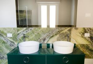 a bathroom with two white sinks on a counter at ApartmentsGarda - Residenza Antiche Mura in Garda
