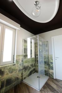 a glass shower in a room with a ceiling at ApartmentsGarda - Residenza Antiche Mura in Garda